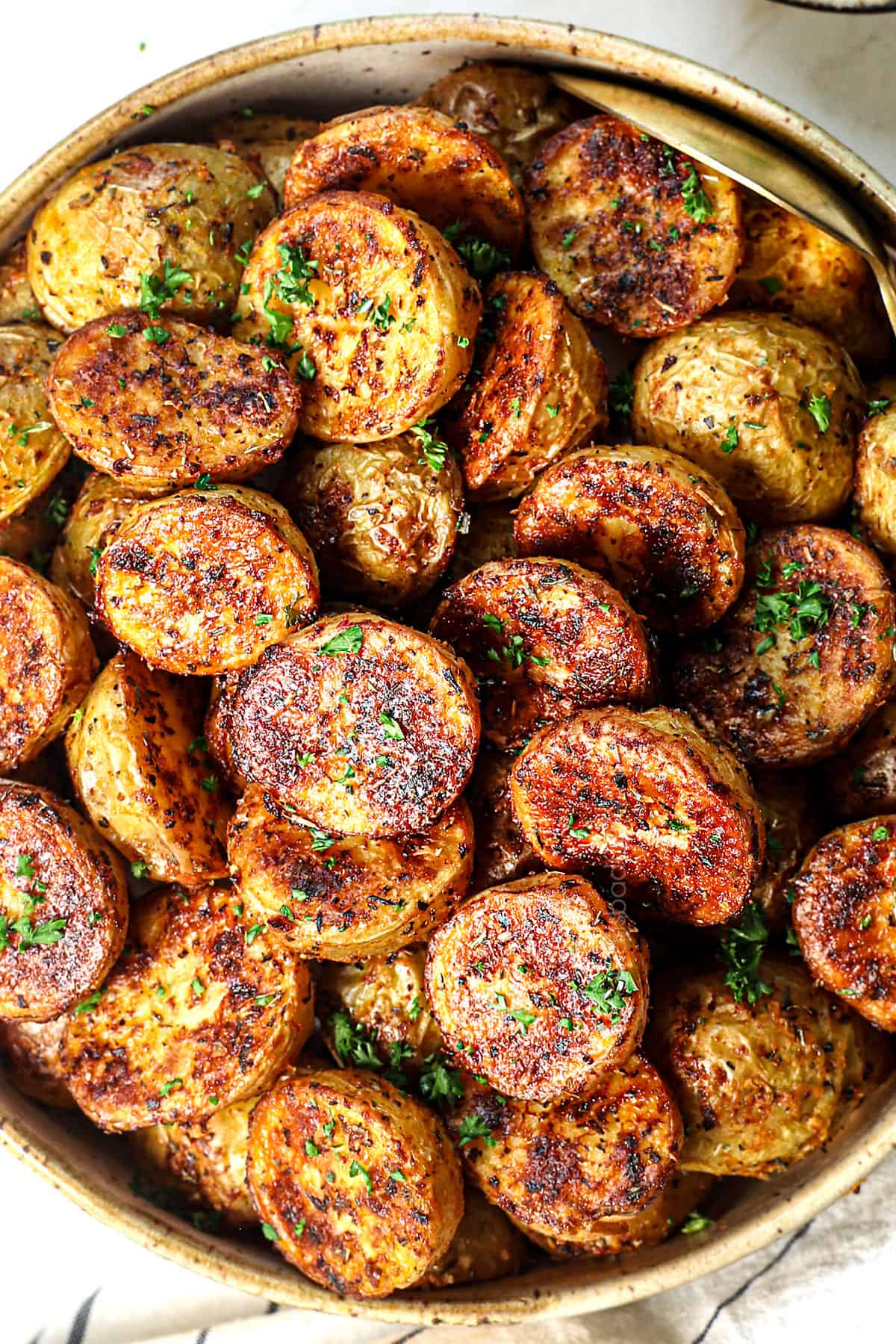 top view of serving roast potatoes in oven in a bowl garnished by parsley