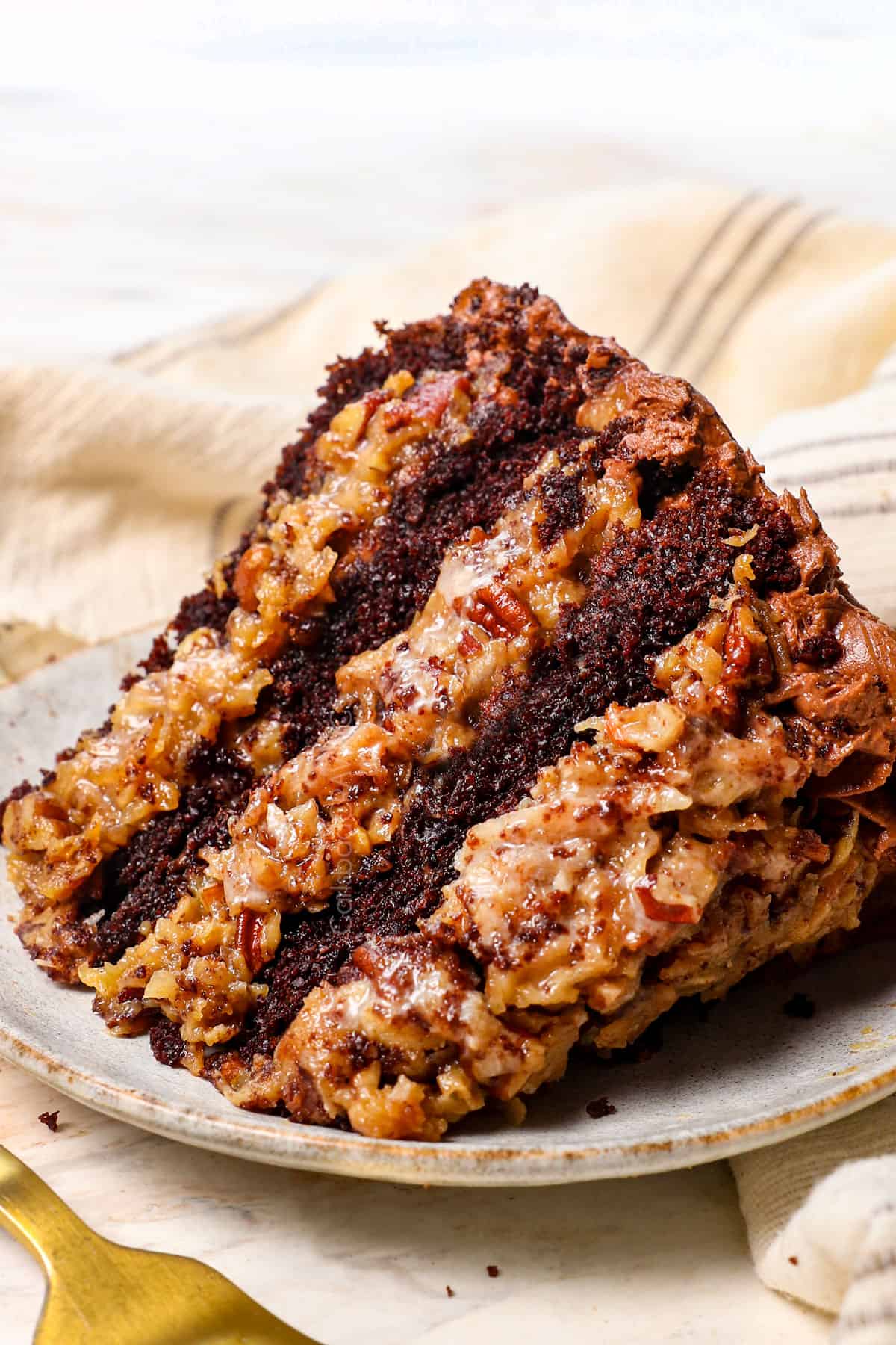 a slice of homemade German chocolate cake on a plate showing how tender the cake is