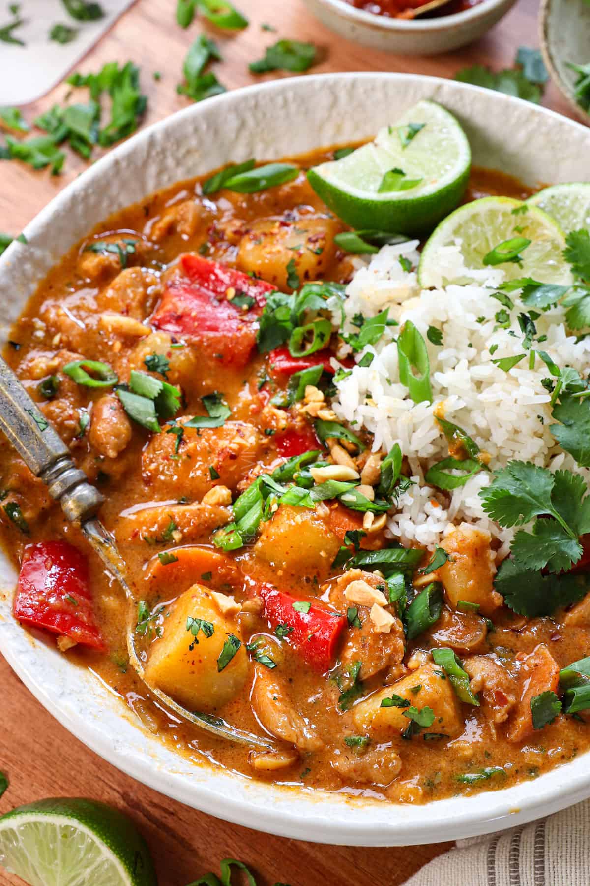 up close of of massaman curry served in a bowl showing the potatoes, chicken, and bell peppers