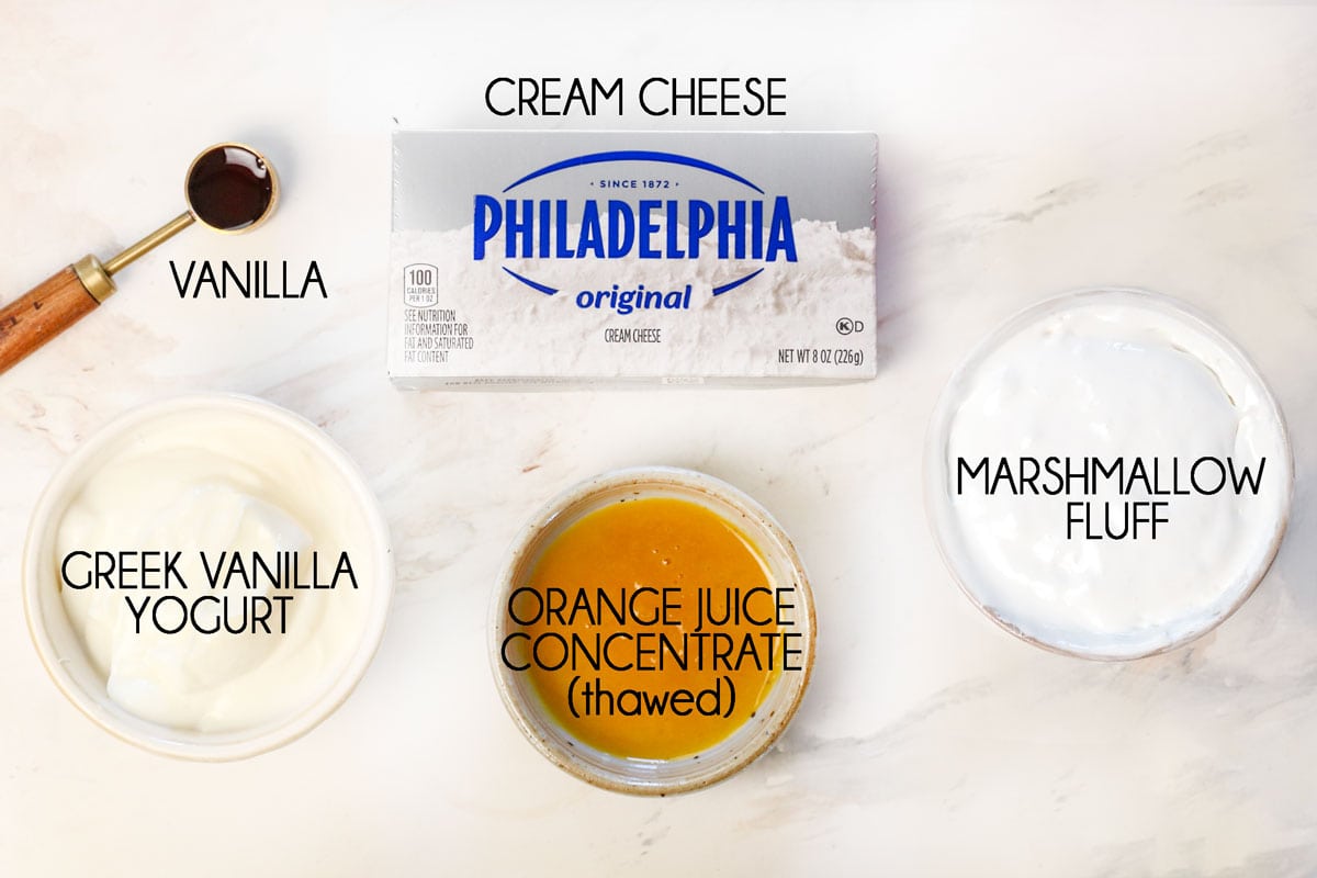 top view of fruit dip ingredients: marshmallow fluff, cream cheese, vanilla yogurt, vanilla extract, orange juice concentrate