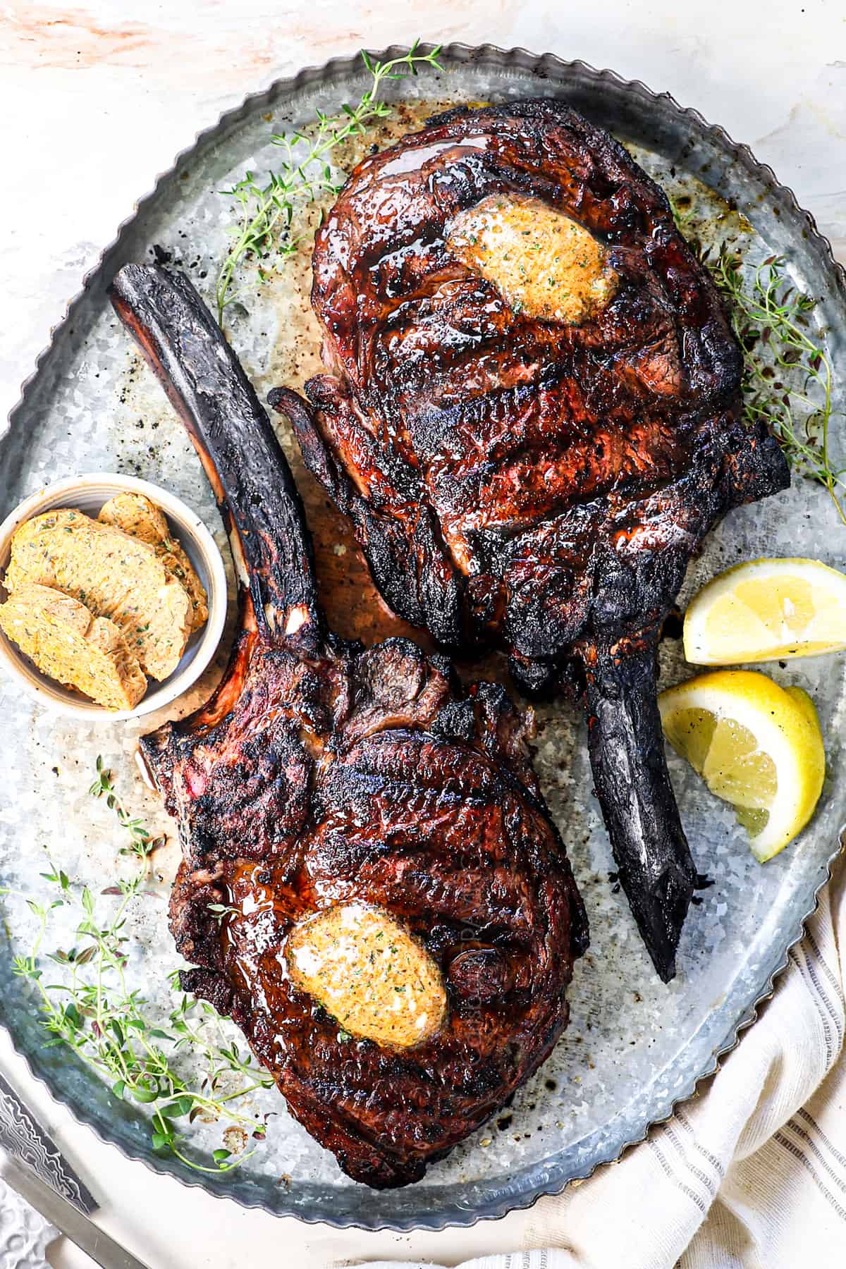 top view of two tomahawk steaks on a platter showing what they look like with the bone