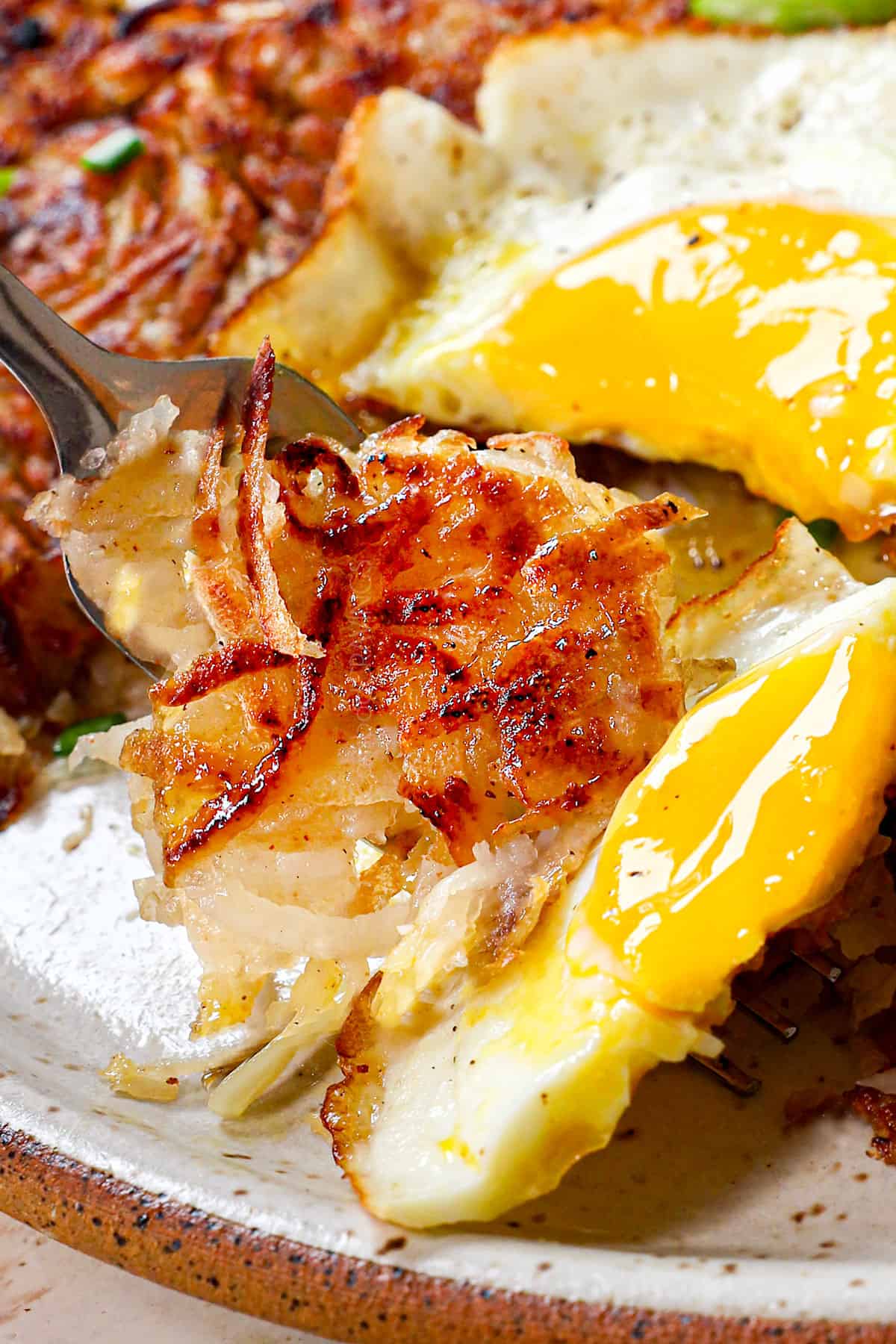 up close of a bite of hashbrown recipe on a fork showing how crispy it is