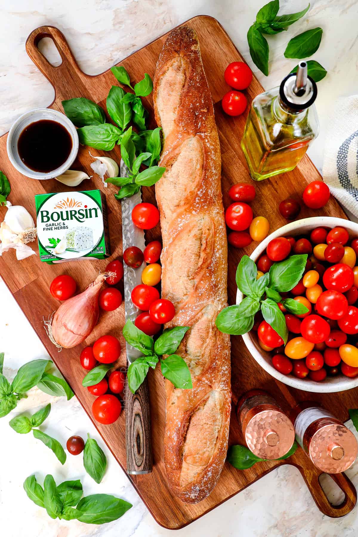 top view of bruschetta ingredients: baguette, tomatoes, basil, garlic, balsamic, olive oil, salt, pepper, shallot, goat cheese, balsamic glaze