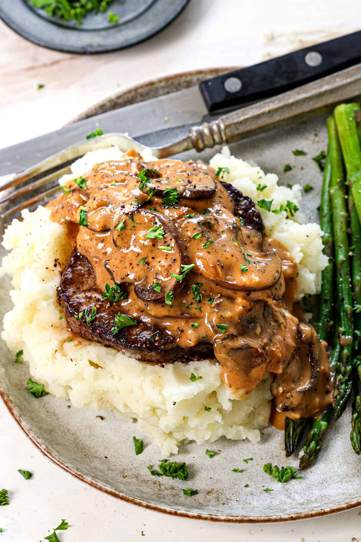 Beef Steak Diane Recipe being served over mashed potatoes, showing how creamy the gravy is