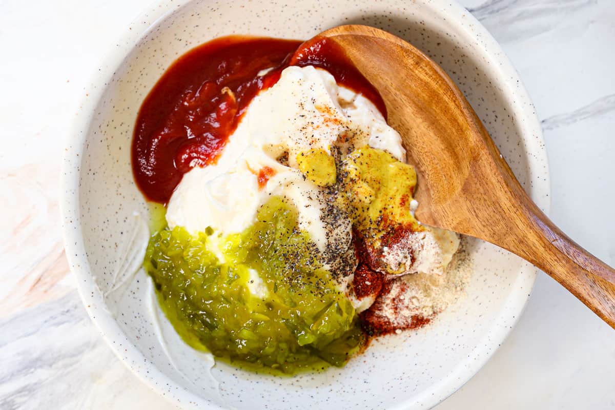 showing how to make smash burgers by making the smash burger sauce by whisking mayonnaise, ketchup, mustard, relish and spices together in a bowl
