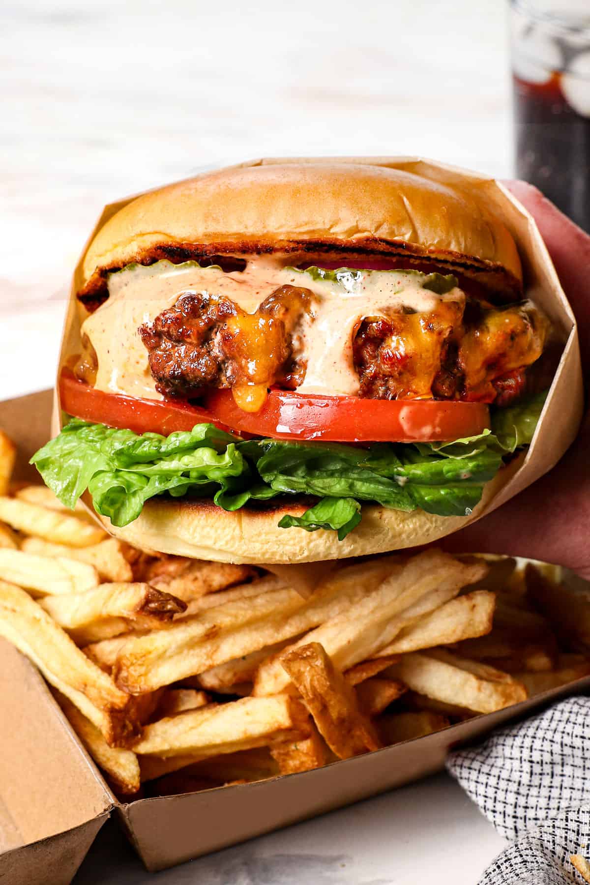 ultimate cheeseburger with burger sauce being held up close to see the juiciness