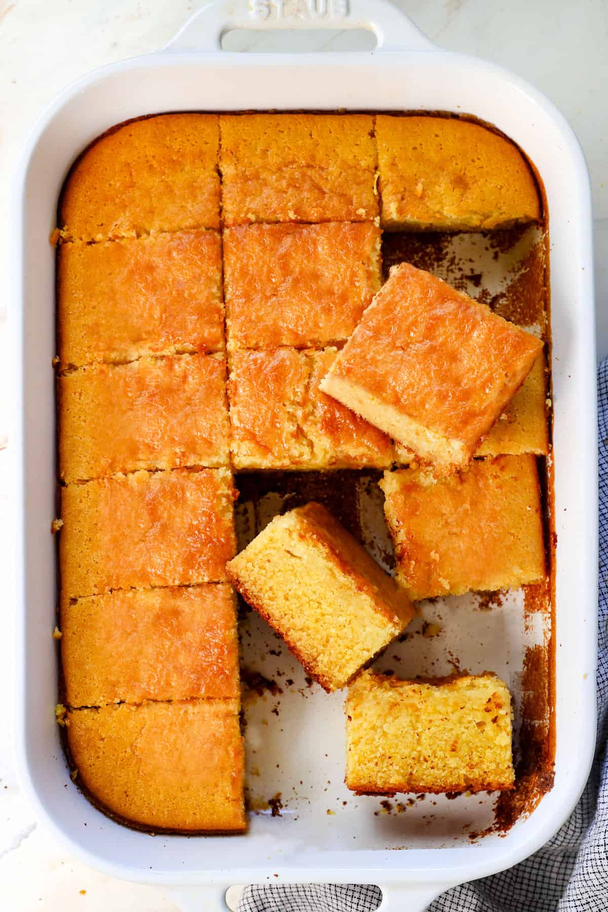 top view of cornbread recipe in a 9x13 pan, showing the golden top and thick slices on their side
