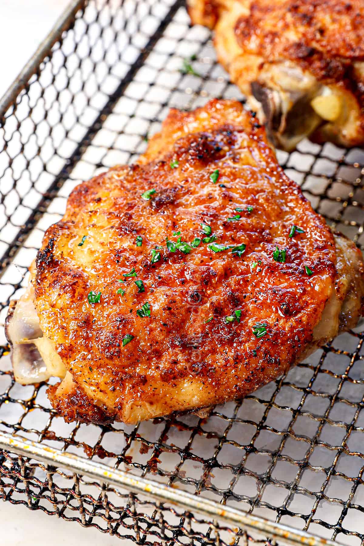 showing how to cook chicken thighs in air fryer by cooking until crispy