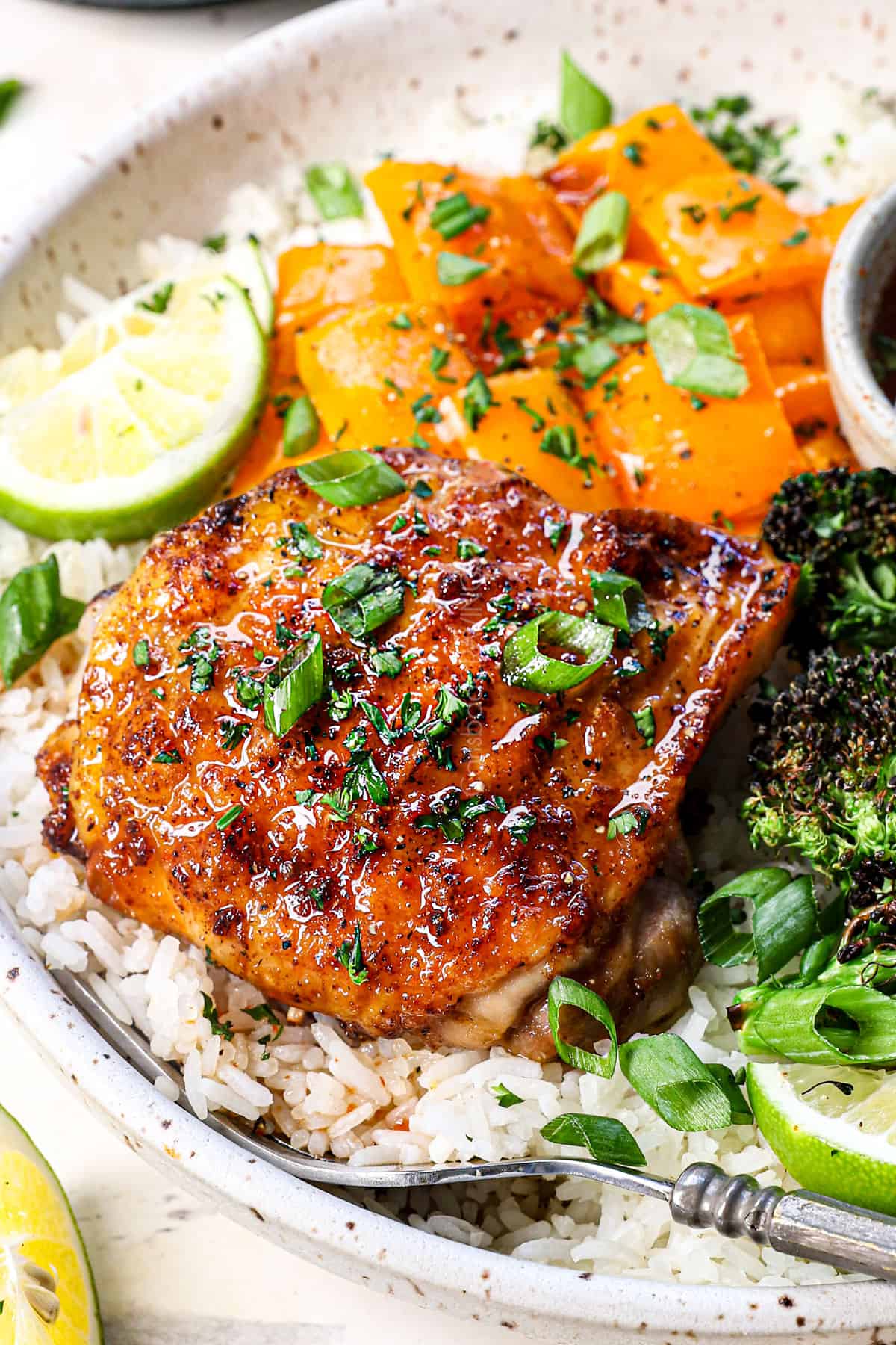 up close of serving air fryer chicken thighs recipe with rice, air fried broccoli and air fried bell peppers