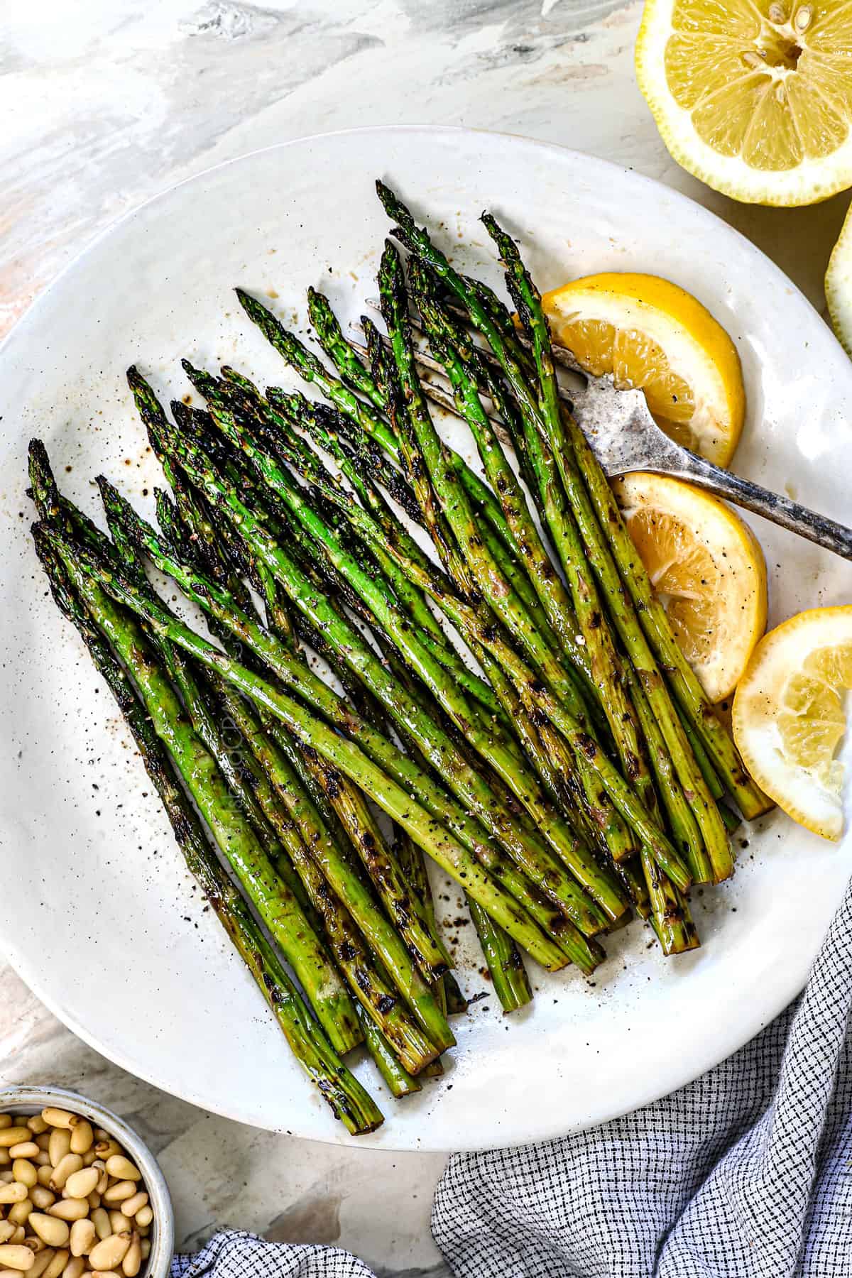 showing how to grill asparagus by transferring it to a platter after grilling