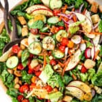 toss salad in a bowl with wood tongs showing how to serve