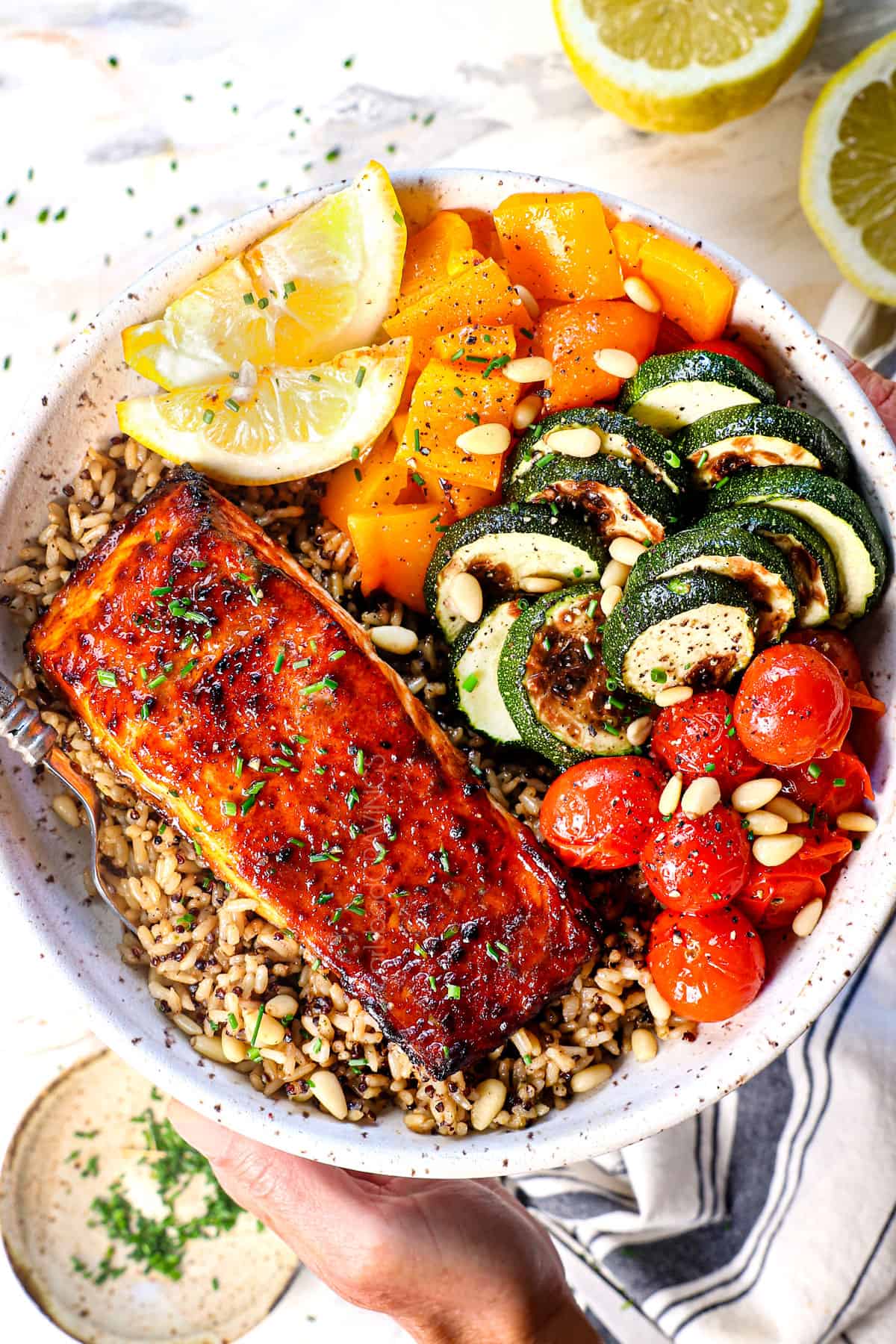 showing how to serve air fryer salmon recipe in a bowl with rice and air fried vegetables