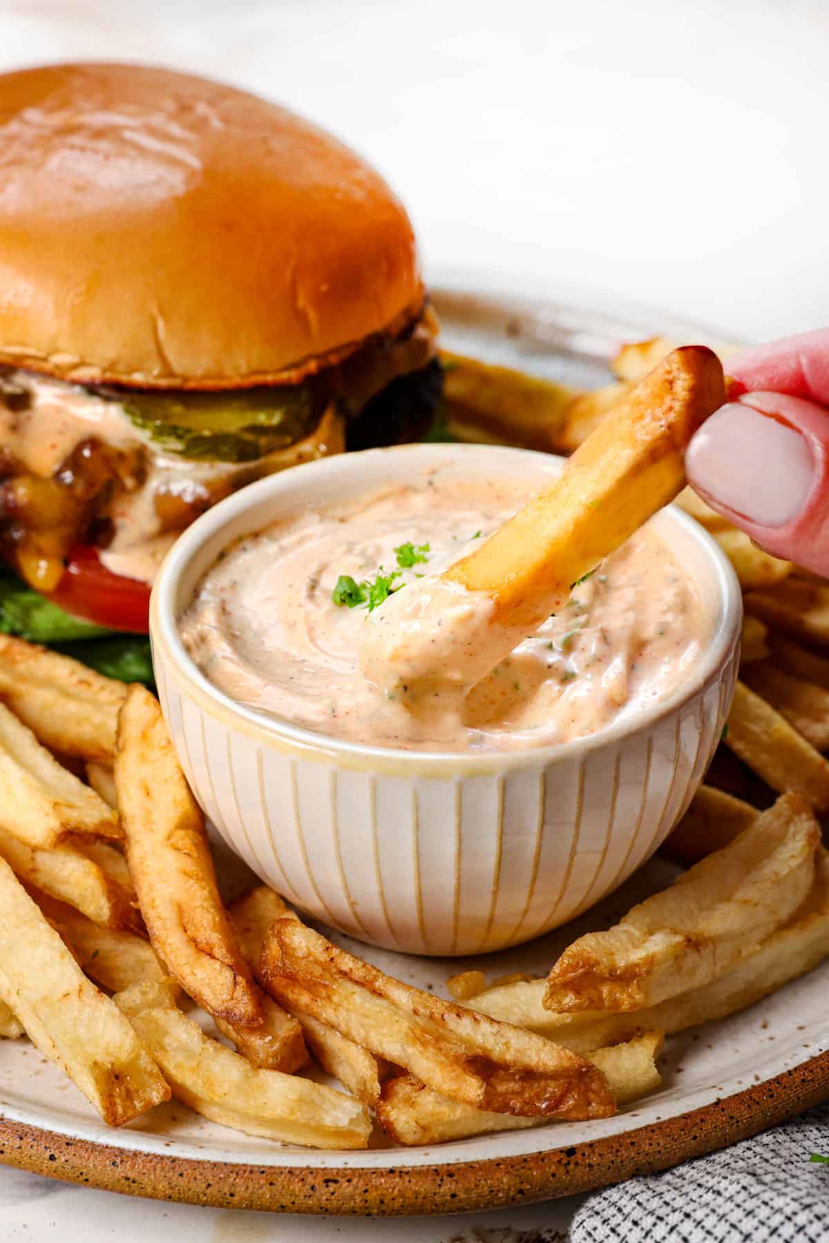dipping a French fry in homemade garlic aioli