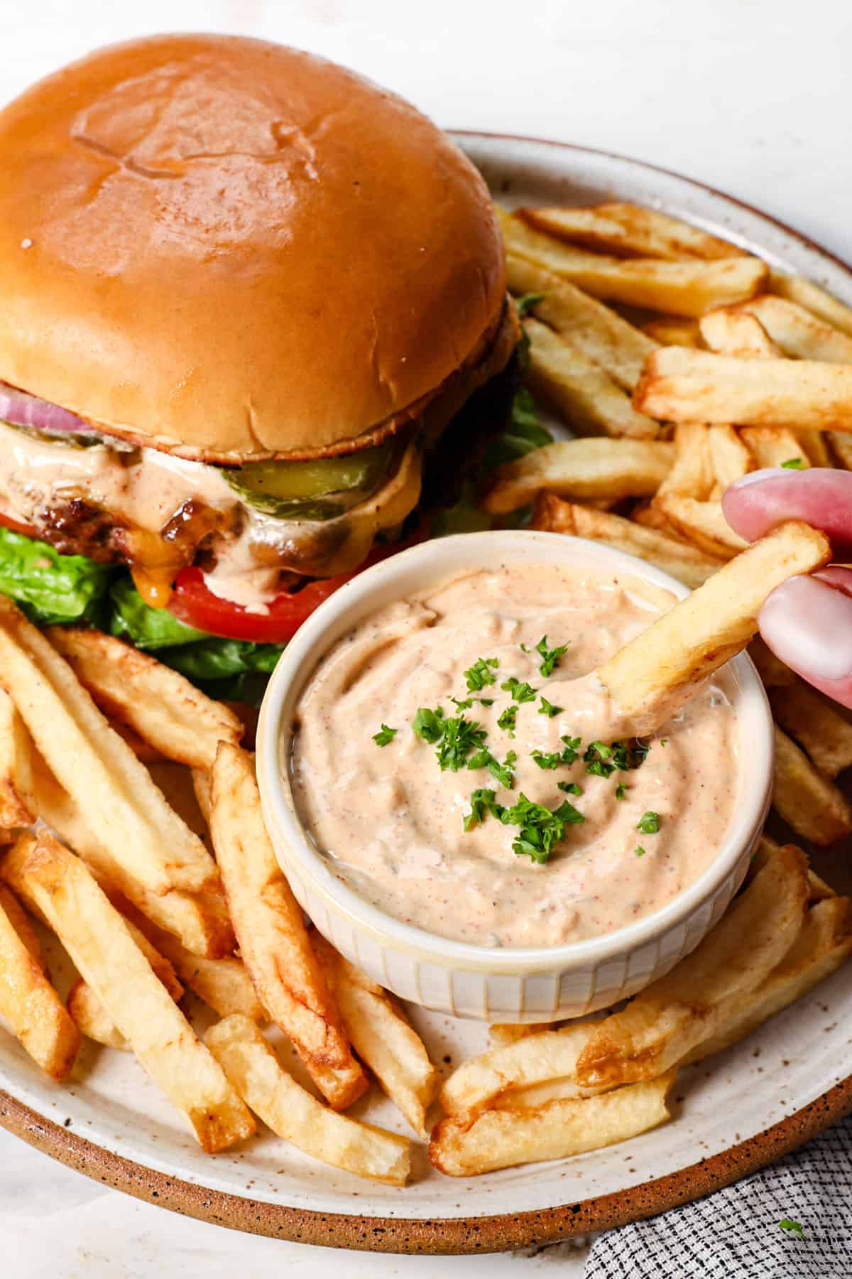 lemon garlic aioli being served with French fries and a hamburger
