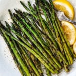 showing how to grill asparagus by transferring it to a platter after grilling