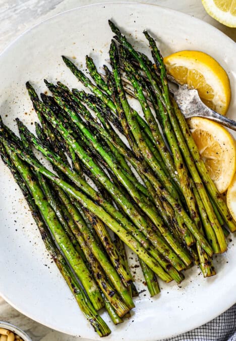 showing how to grill asparagus by transferring it to a platter after grilling