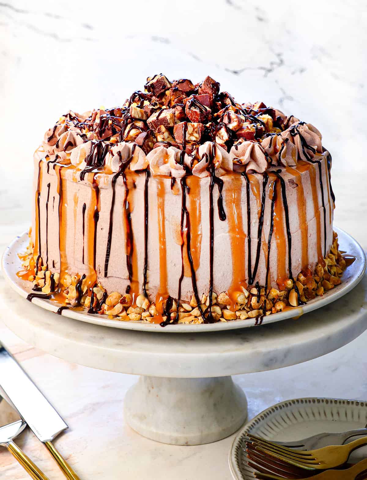 showing how to make an ice cream cake by drizzling with chocolate fudge sauce and caramel to decorate