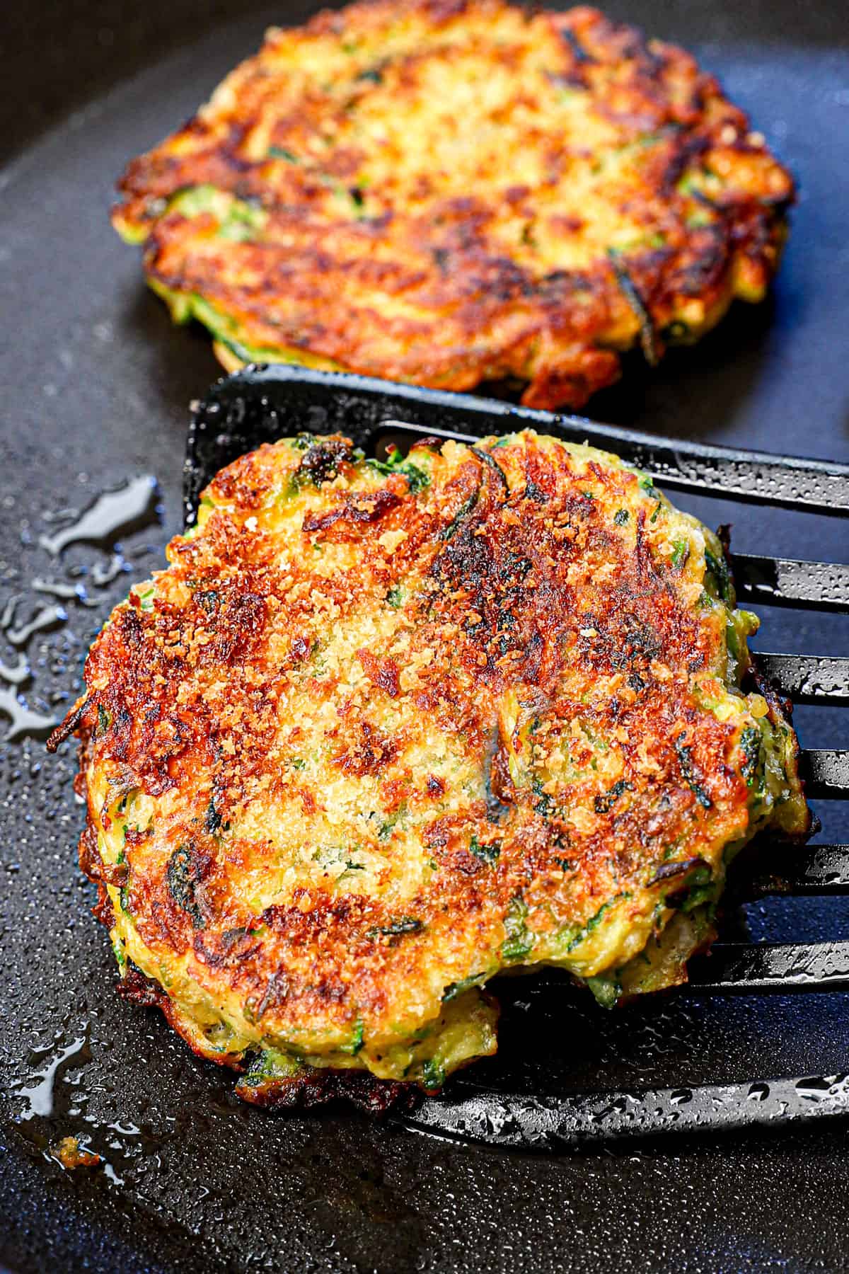 showing how to make zucchini fritters by cooking until golden brown and crispy on the outside