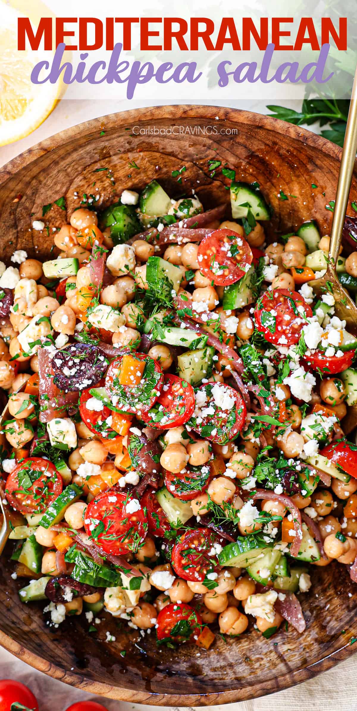 top view of chickpea salad in a wood bowl with chickpeas, tomatoes, cucumber, feta, bell pepper, dill