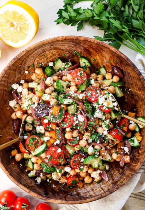 top view of tossing garbanzo bean salad in a bowl
