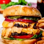 best smash burger recipe with cheese on a cutting board with fries