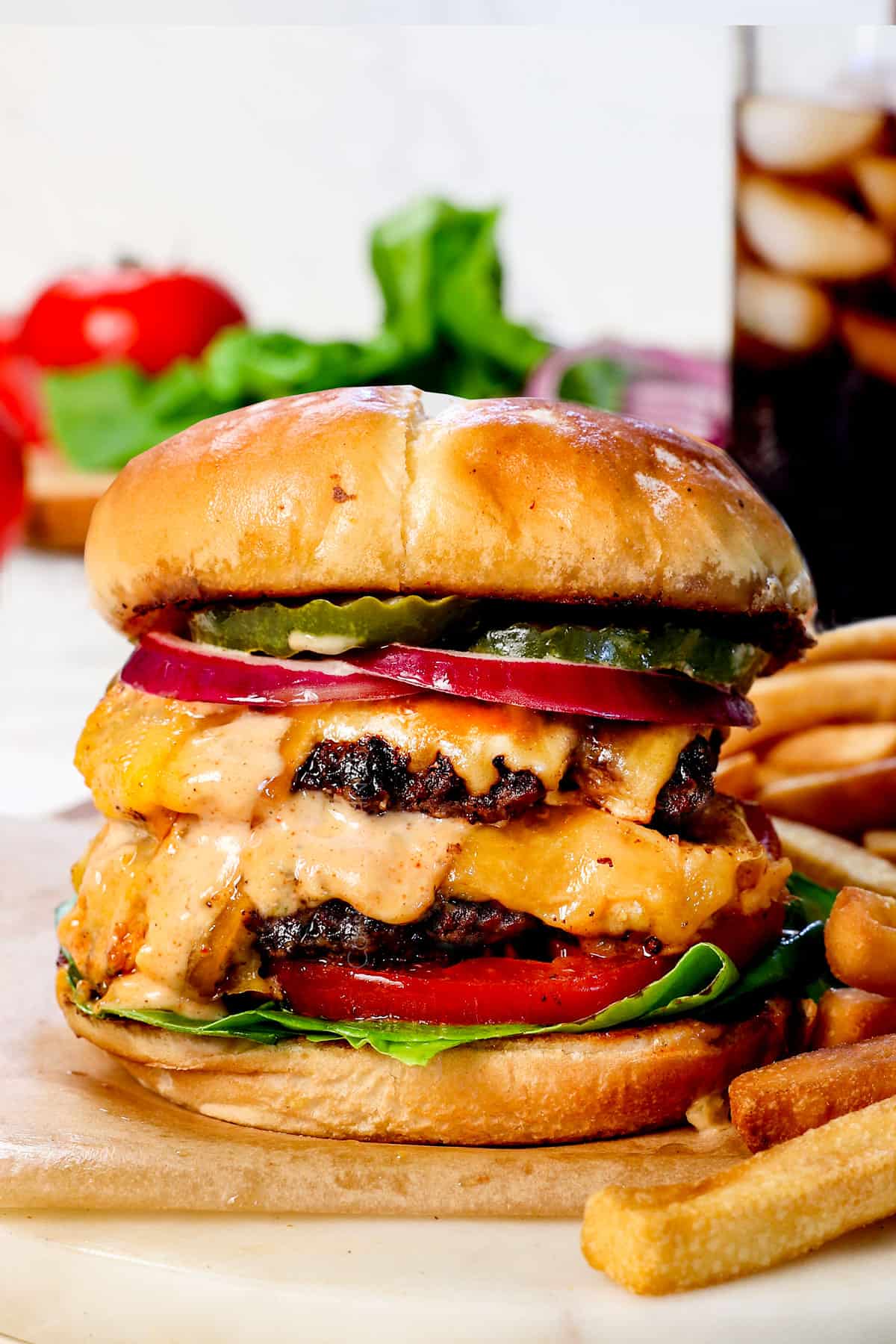 best smash burger recipe with cheese on a cutting board with fries