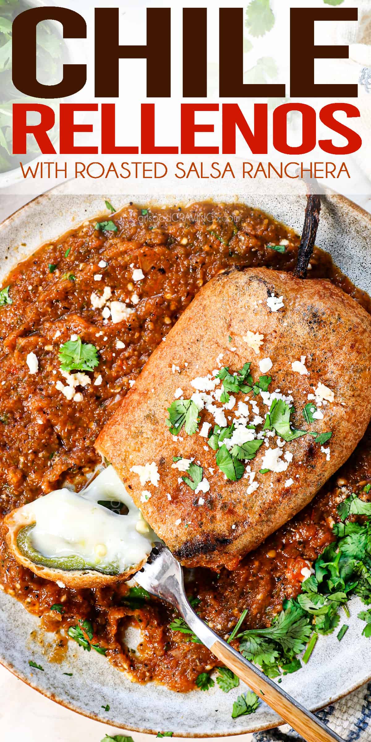 top view of chile relleno being served on a plate with a bite taken showing the oozing cheese