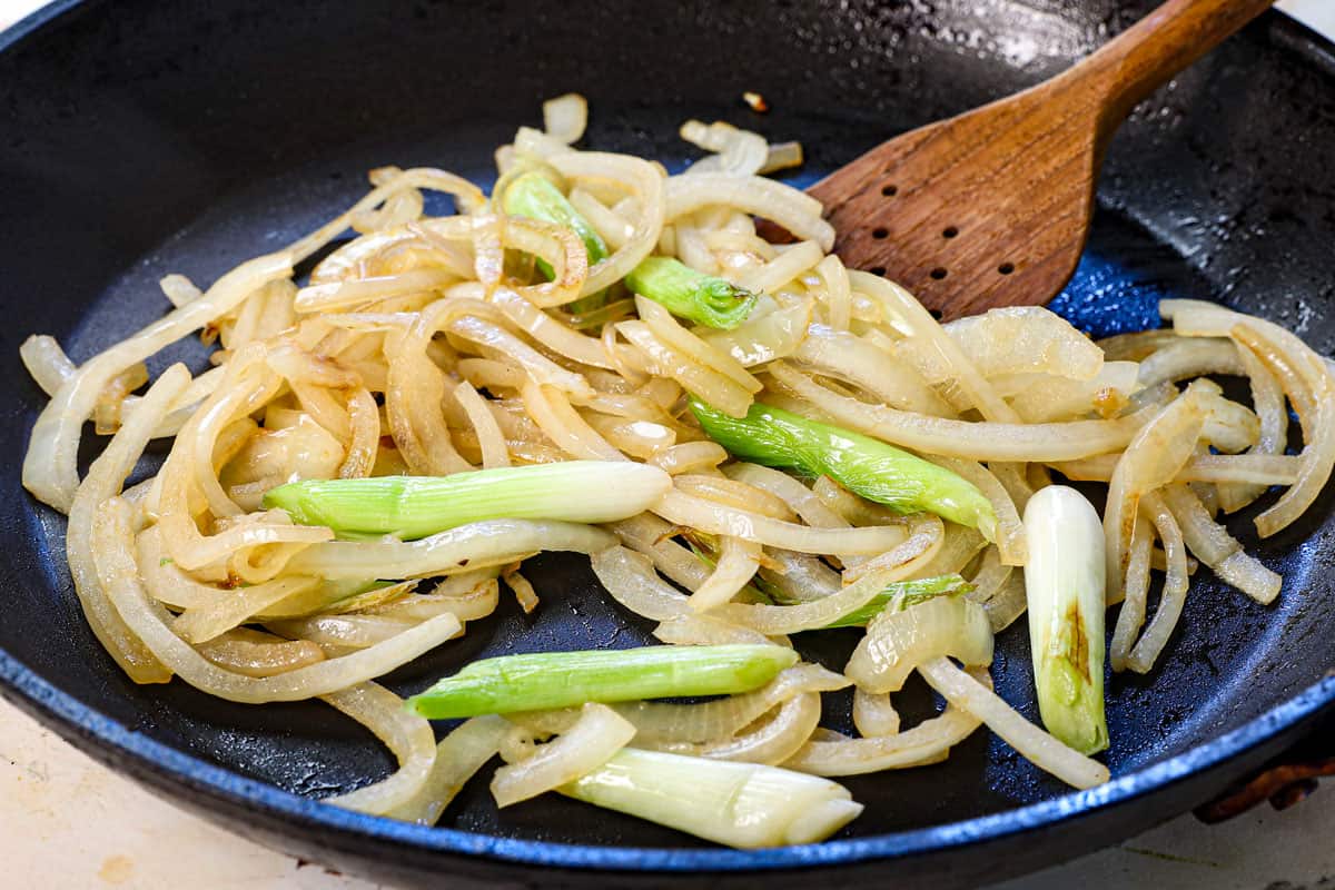 showing how to make japchae cooking the sliced onion and the white parts of the green onions
