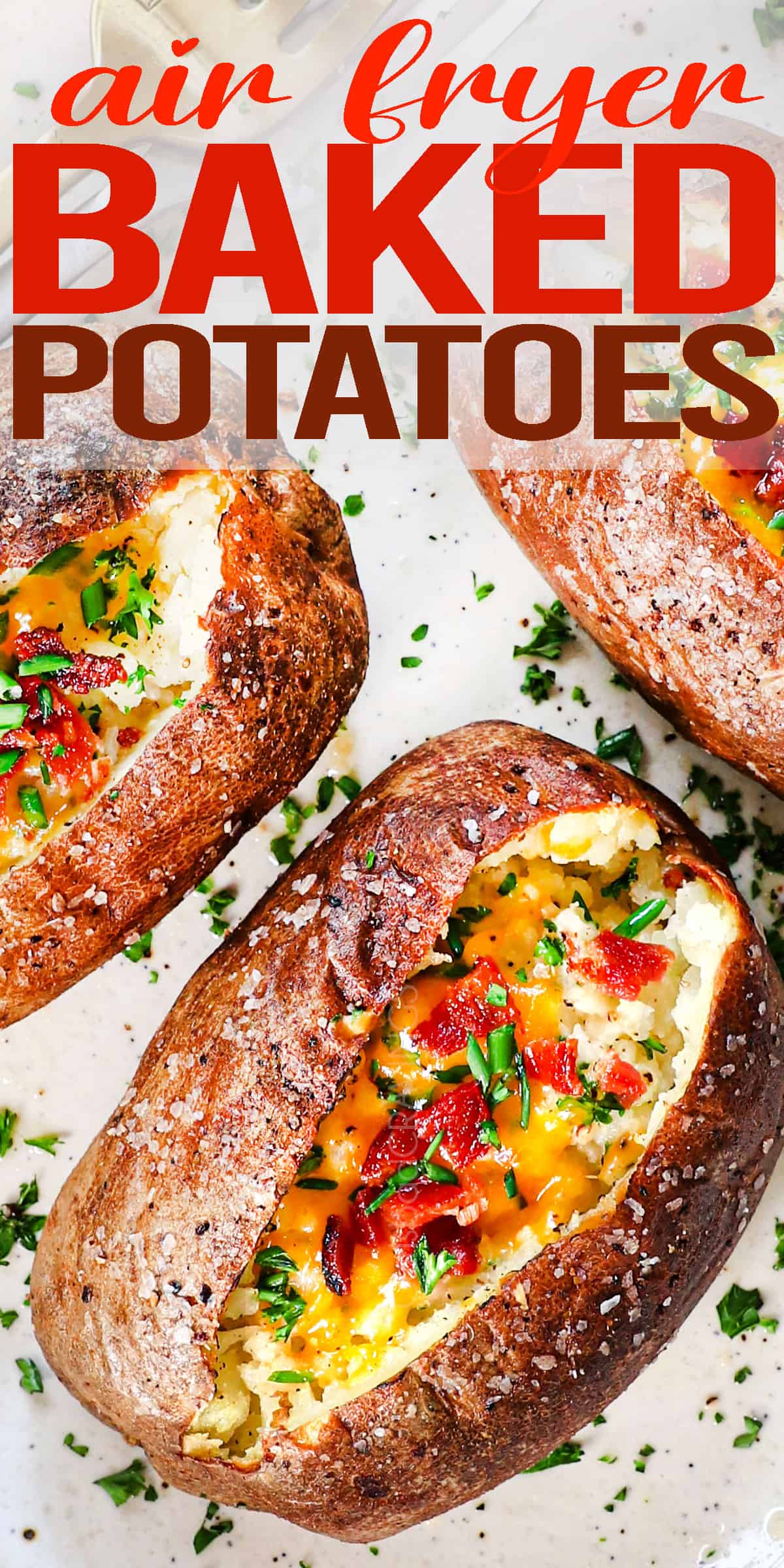 up close of baked potatoes in air fryer being served on a plate garnished with green onions