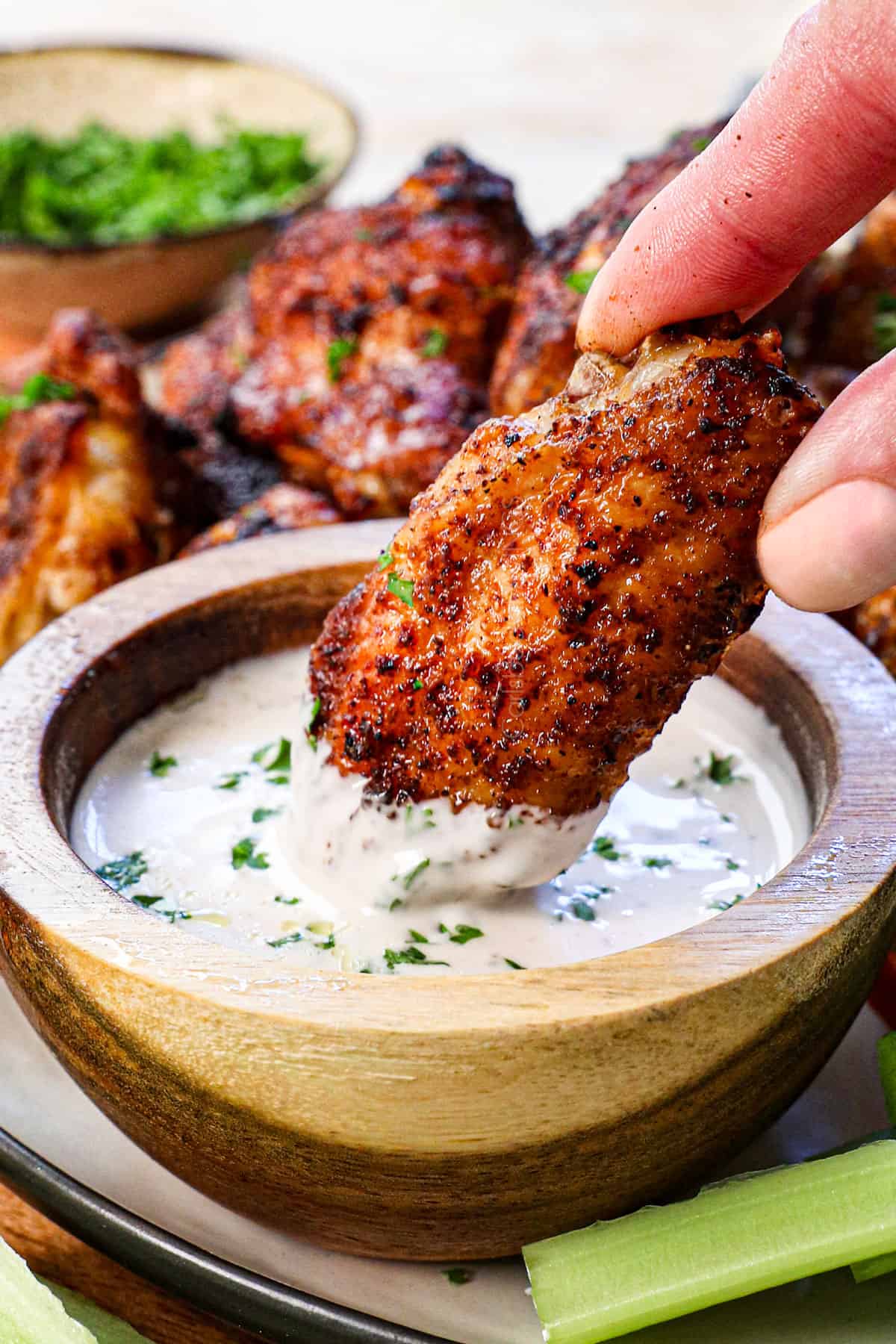 showing how to serve wings in air fryer by dipping into sauce