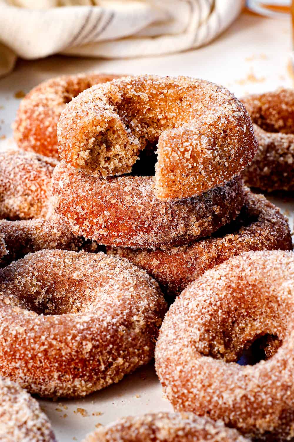 apple cider donuts recipe with a bite taken out of the donut showing how tender and fluffy it is inside