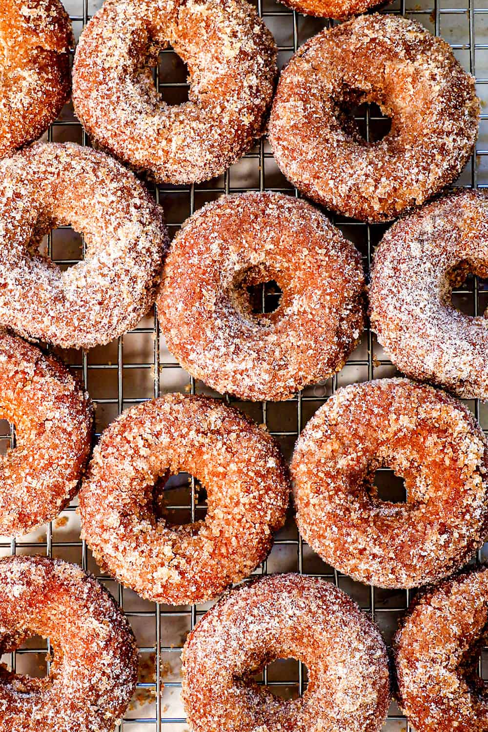 showing how to make apple cider donut recipe by transferring donuts to wire rack