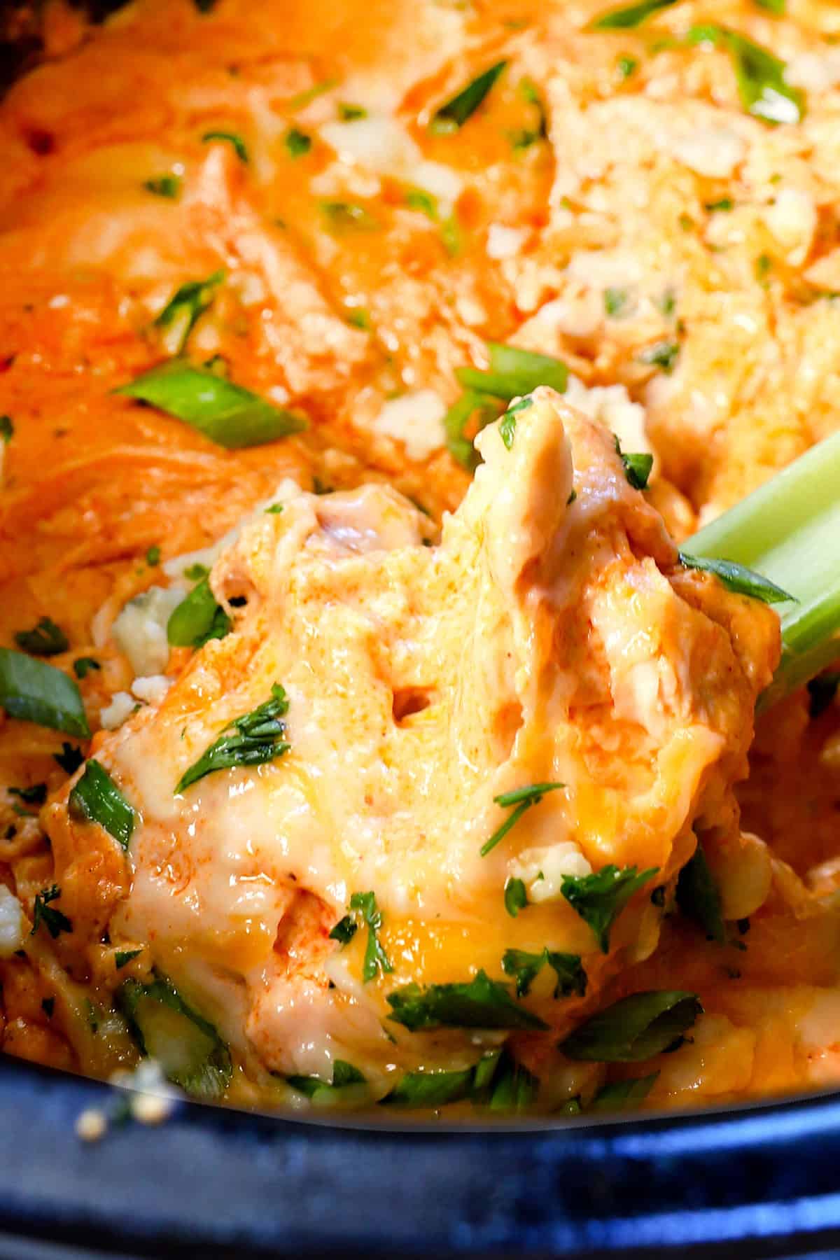 up close of a big bite of crockpot buffalo chicken dip recipe showing how creamy it is