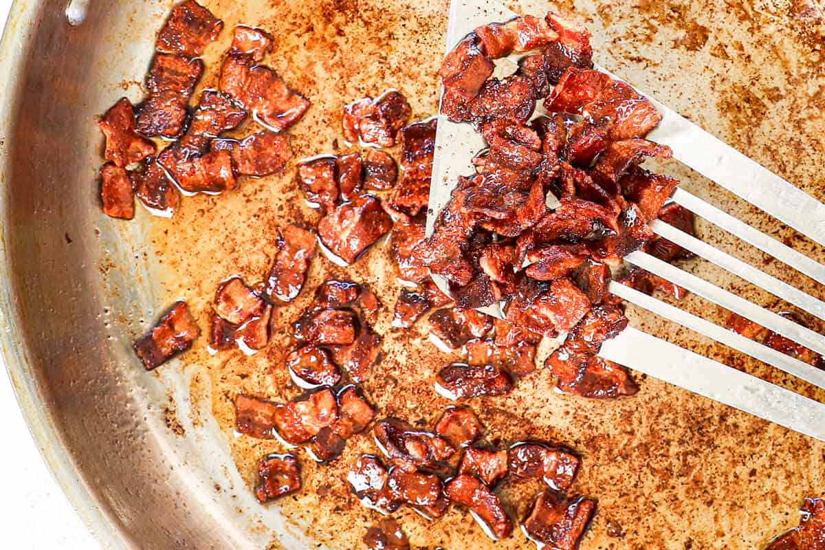 showing how to make creamed corn by cooking the bacon until crispy