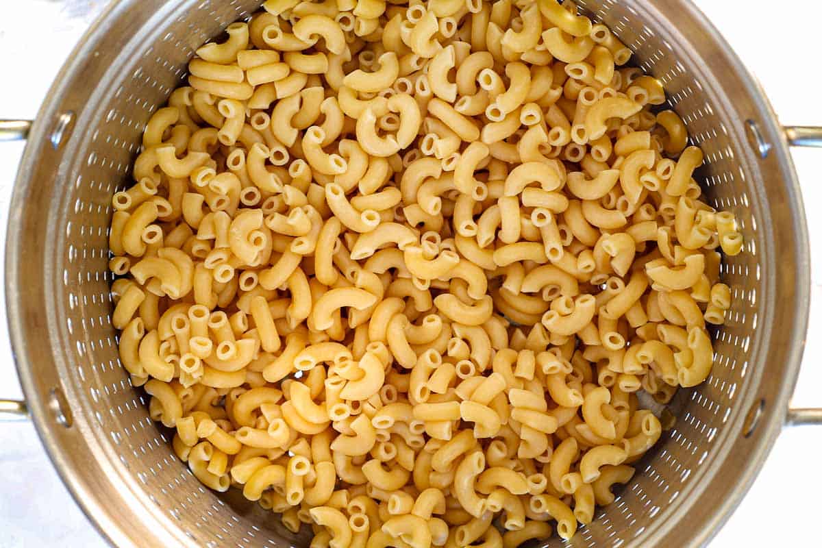 showing how to make Mac and Cheese Bites by cooking pasta in a pot until al dente