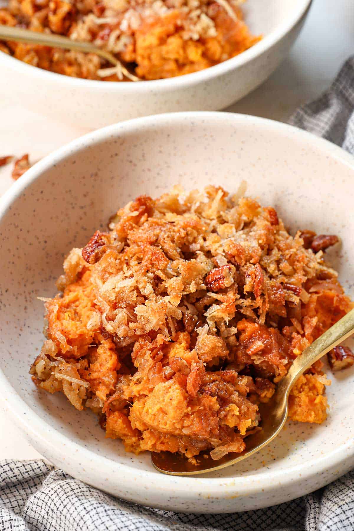 up close of a bowl of sweet potato casserole with coconut showing the crunch topping