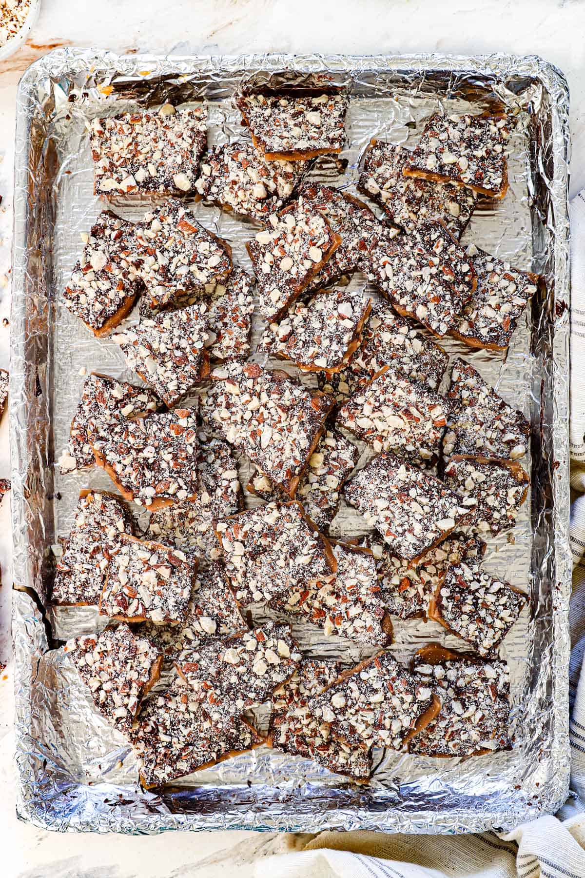 top view of almond roca recipe broken into pieces on a baking sheet