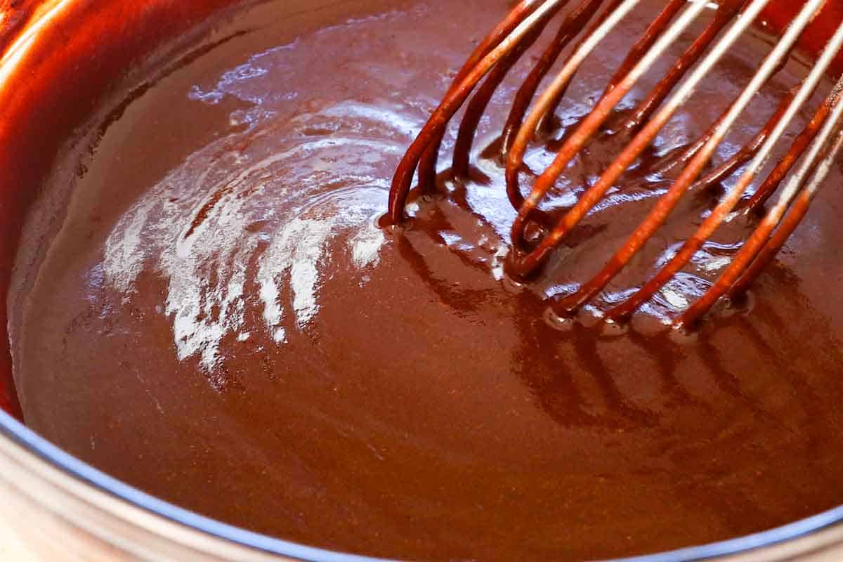 showing how to make Chocolate chess Pie by whisking the chocolate ganache ingredients until smooth
