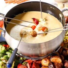 fondue recipe with dippers being dipped in the cheese