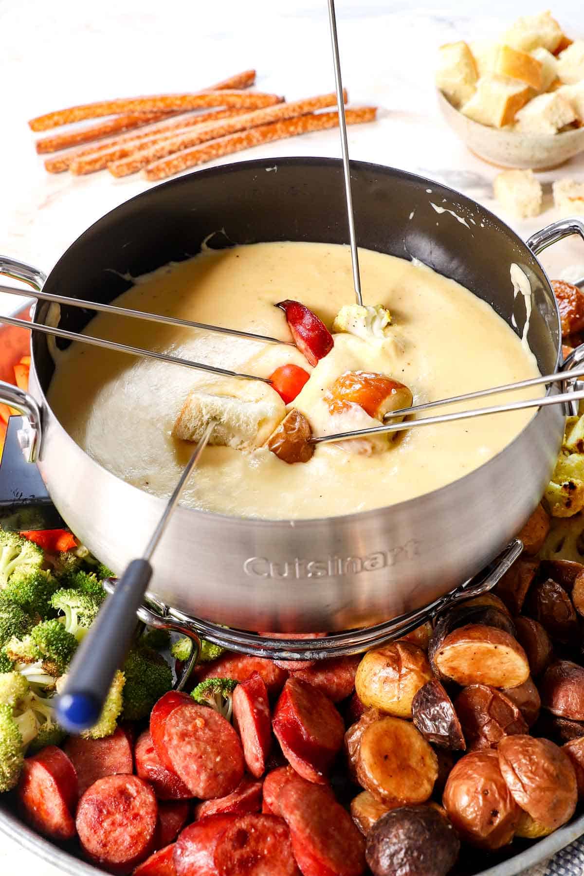 fondue recipe with dippers being dipped in the cheese