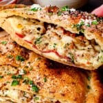 up close of holding up a bitten calzone to show the filling inside