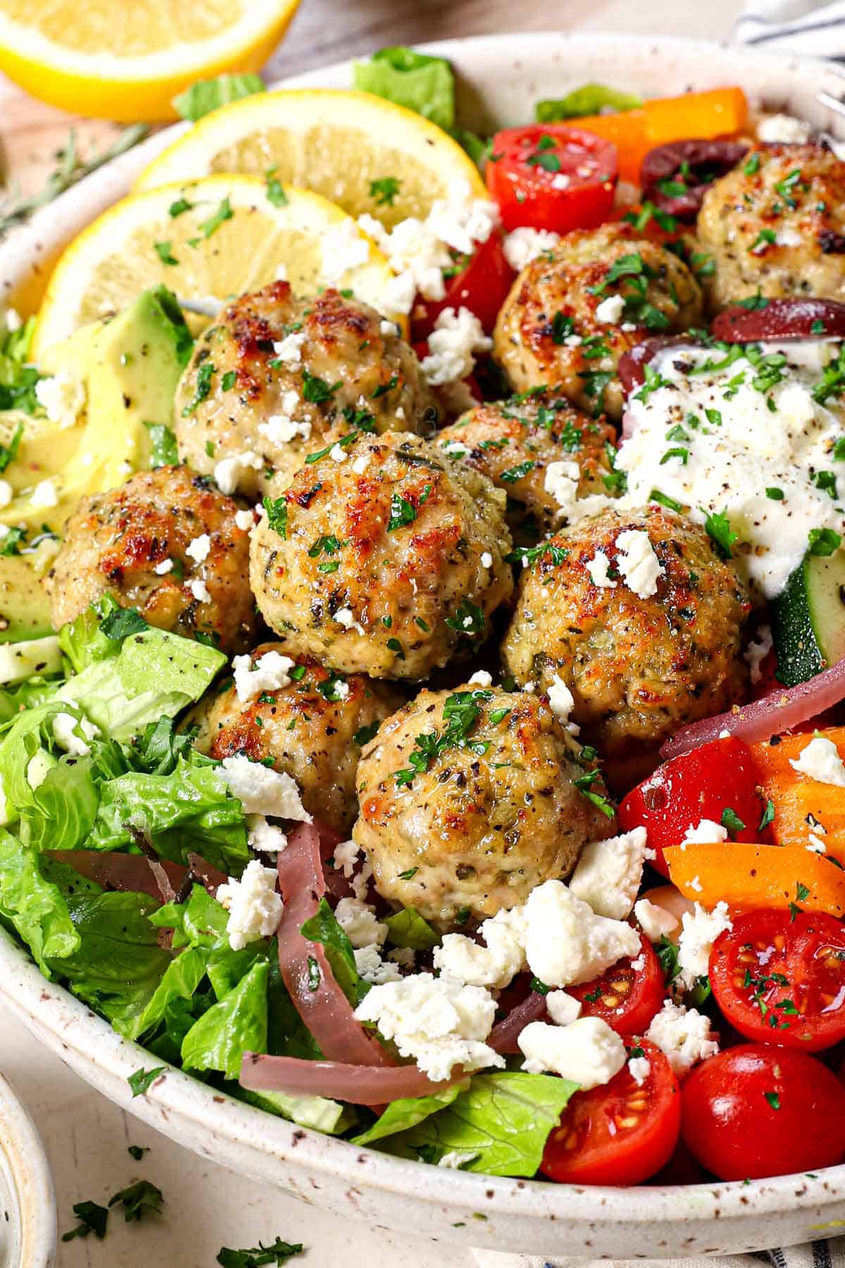 side view of chicken meatballs being served in a Greek bowl