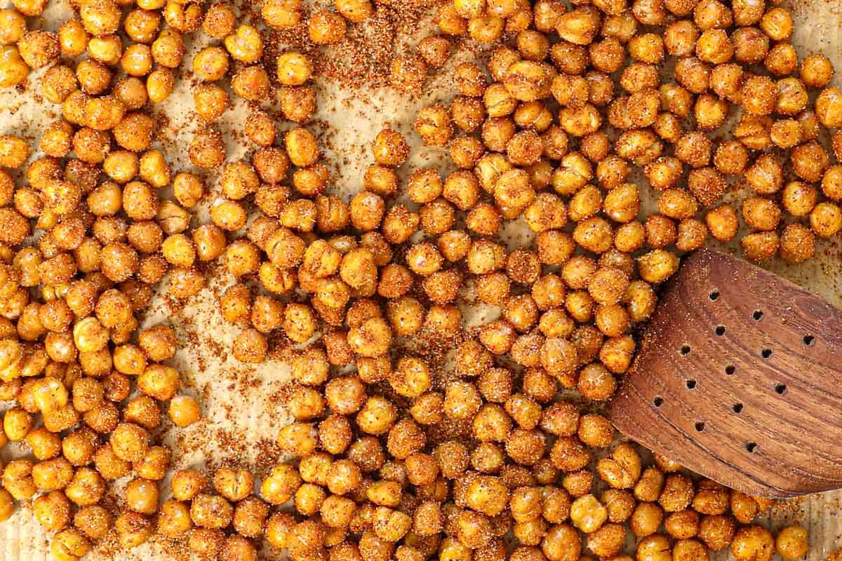 showing how to roast chickpeas by tossing the chickpeas with olive oil, followed by spices