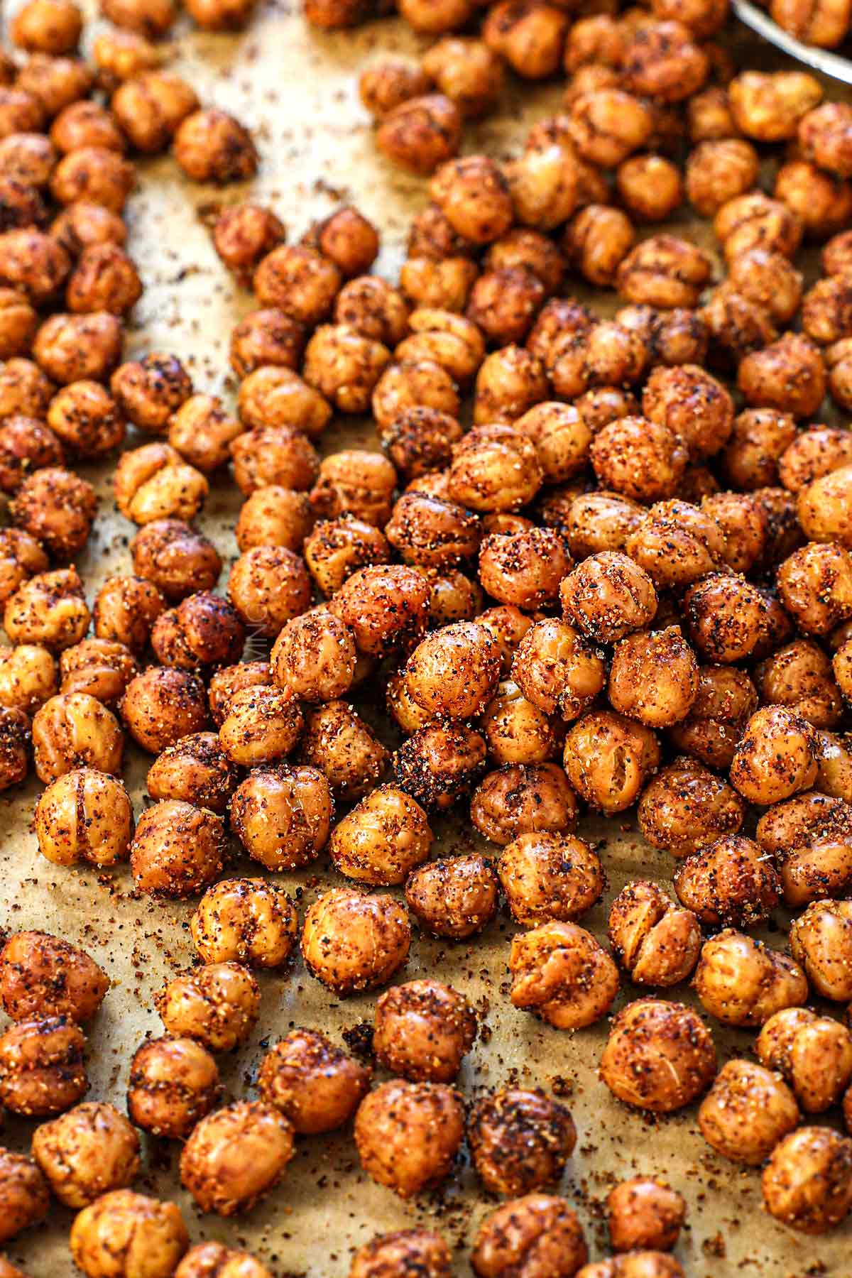 up close of roast chickpeas on a baking sheet showing how crispy they are