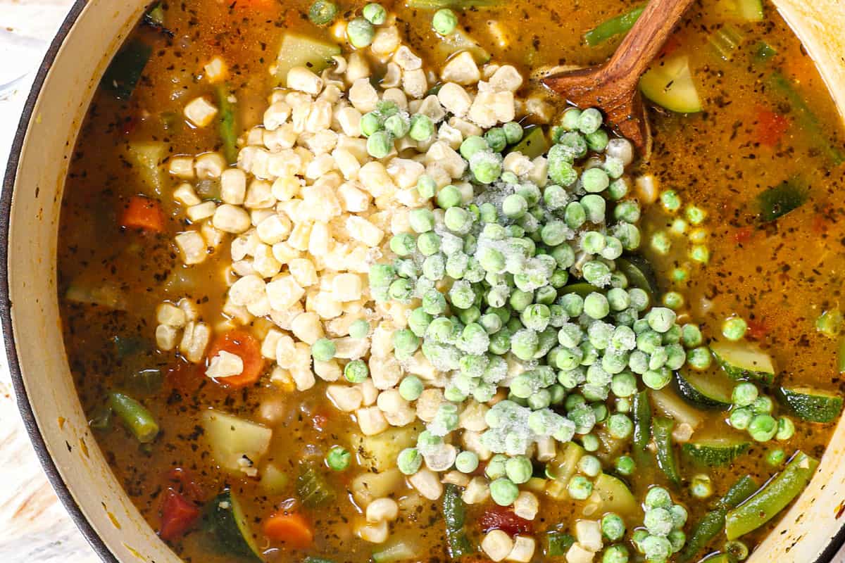 showing how to make vegetable soup by adding frozen peas and corn and simmering