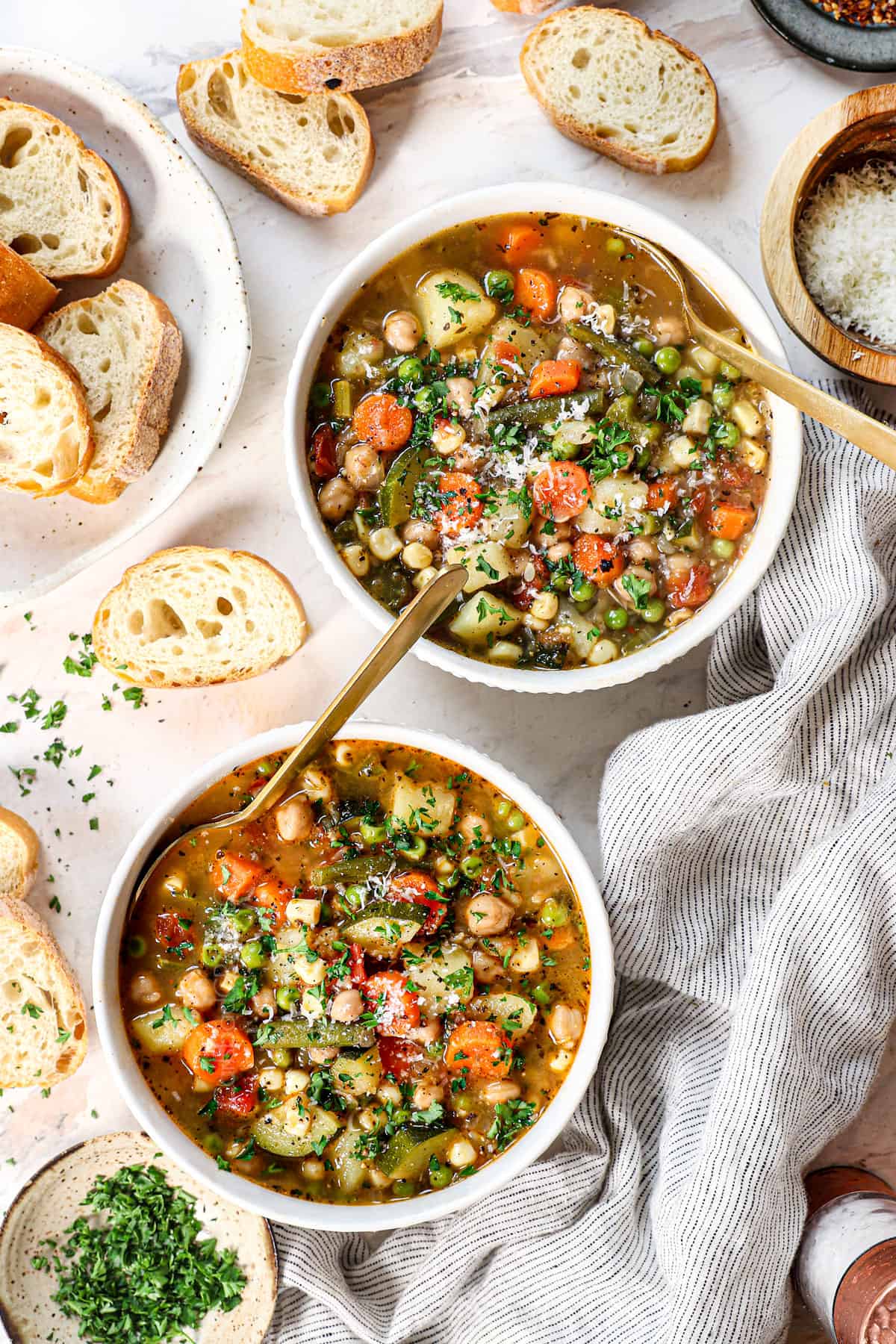 top view of two bowls of vegetable soup recipe being served with bread