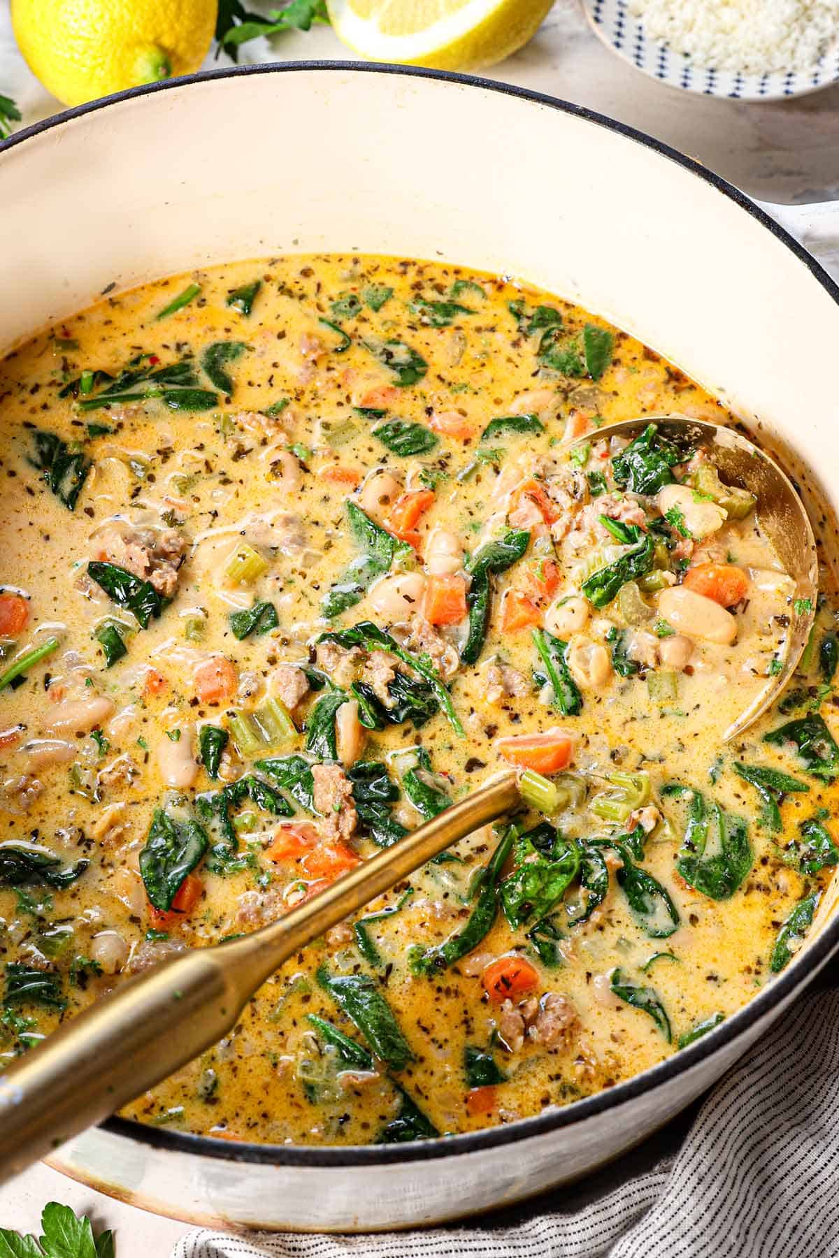 a ladle of white bean and kale soup showing the hearty texture