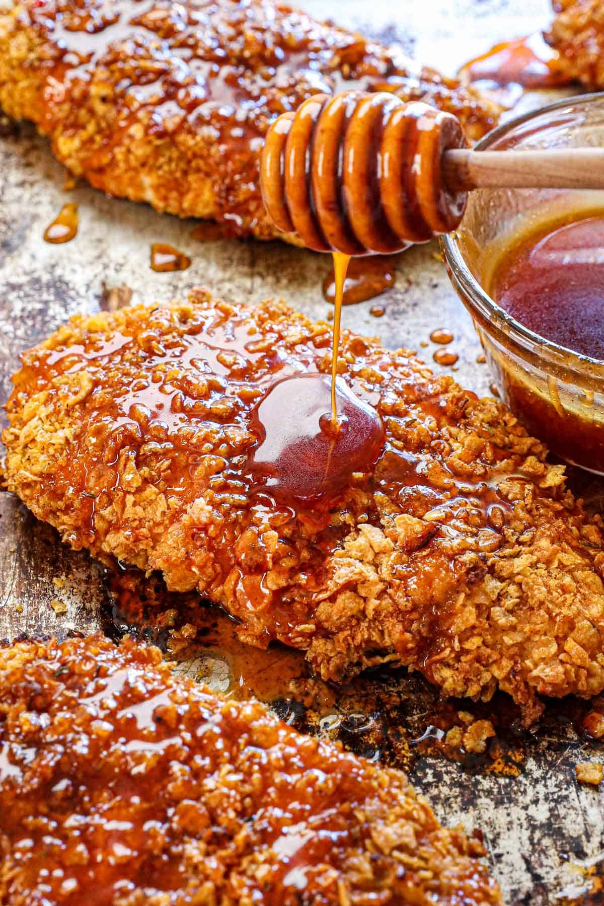 showing how to make Hot Honey Chicken by drizzling the crispy breaded chicken with hot honey