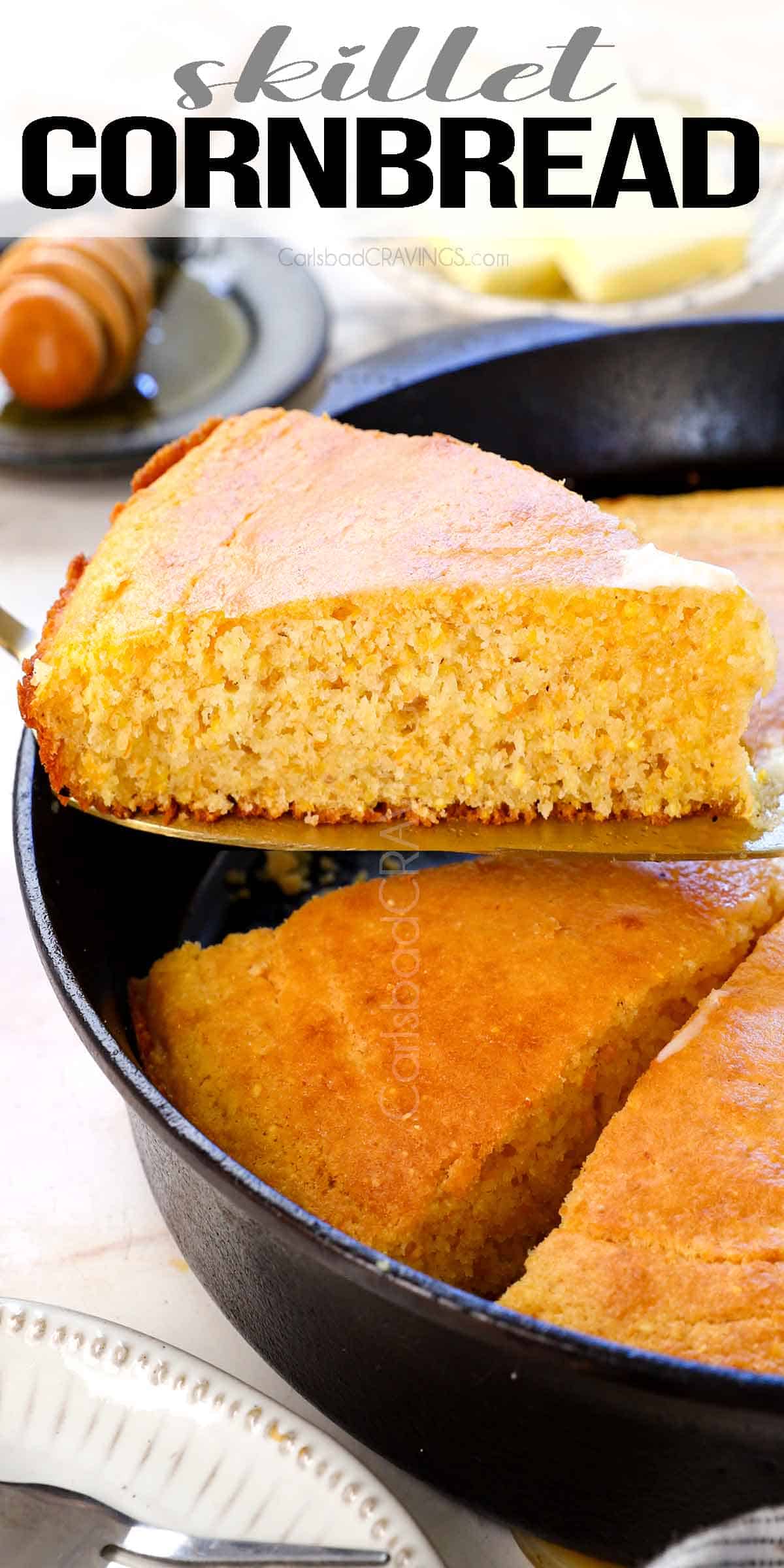 Up close of holding up a slice of skillet cornbread from the cast iron skillet showing the tender, moist texture