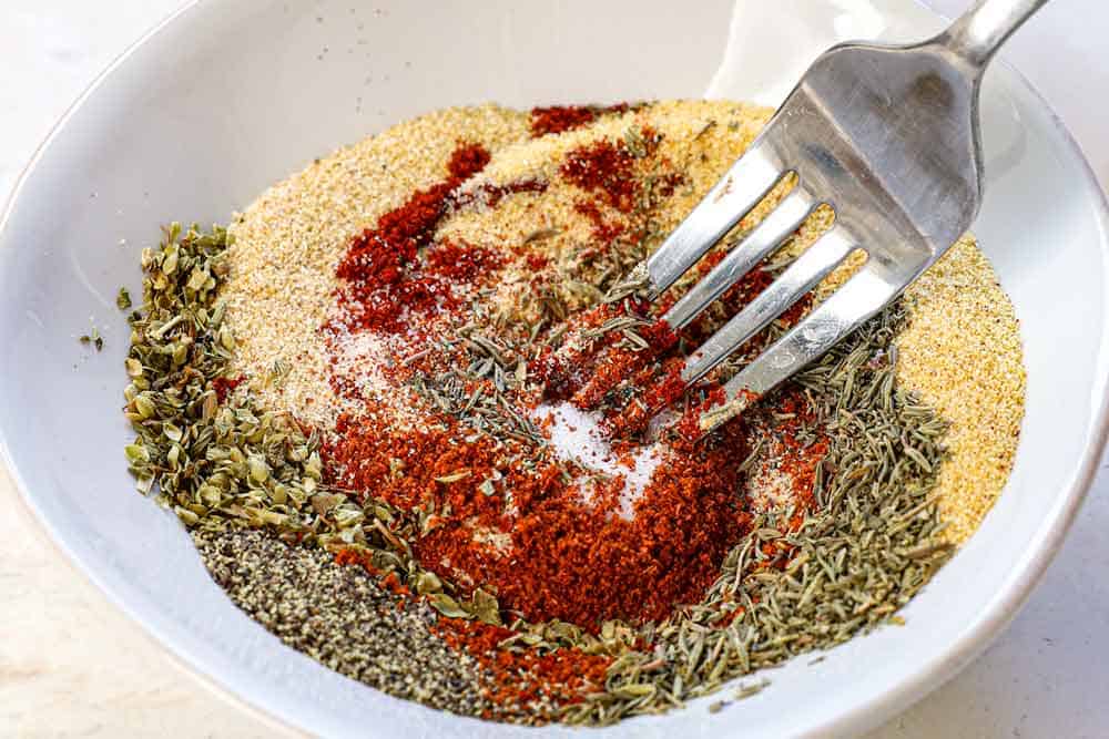 showing how to make jambalaya by whisking the homemade Cajun seasoning spices together in a bowl